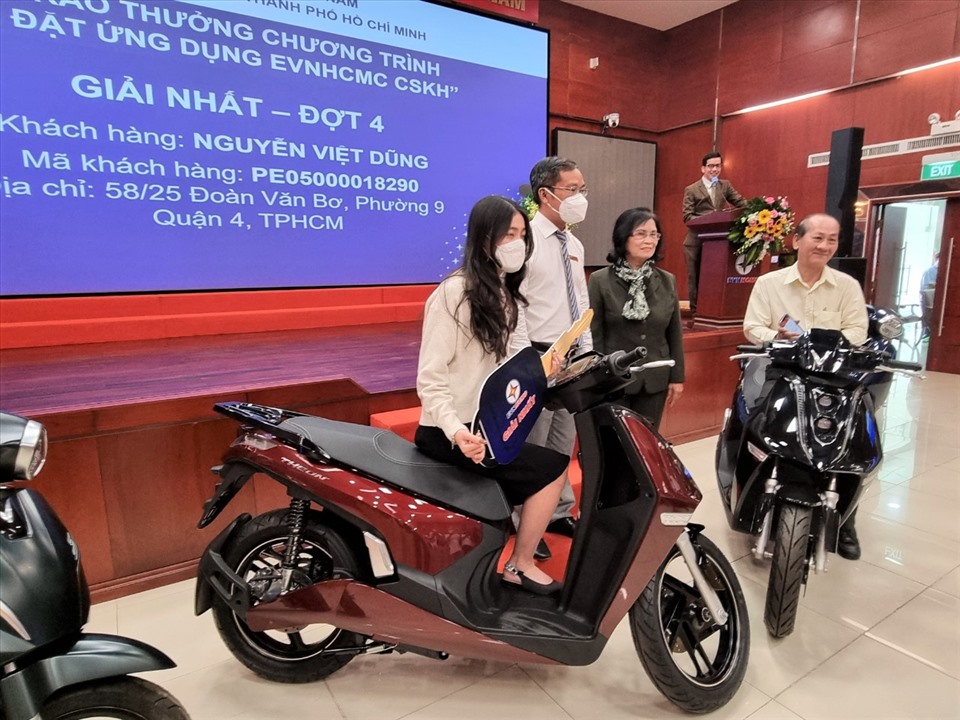Đại diện EVNHCMC và Hội Bảo vệ quyền lợi người tiêu dùng TPHCM chụp hình chung với 2 khách hàng trúng giải Nhất (xe máy VinFast Theon (kèm pin) trị giá 85 triệu đồng/xe) chương trình “Cài App EVNHCMC CSKH trúng thưởng”. Ảnh: Nam Dương