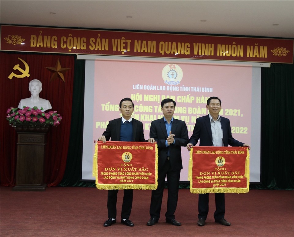 Chủ tịch LĐLĐ tỉnh Thái Bình - Bùi Xuân Vinh tặng cờ thi đua của LĐLĐ tỉnh cho các tập thể tại hội nghị. Ảnh: B.M