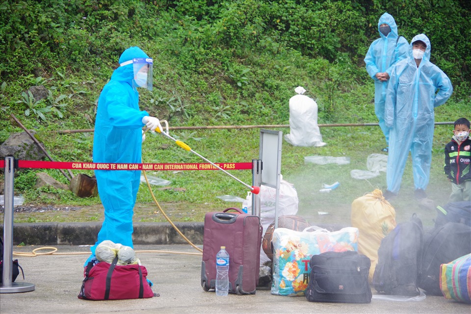Nhân viên y tế tiến hành phun khử khuẩn toàn bộ hành lý của công dân nhập cảnh.