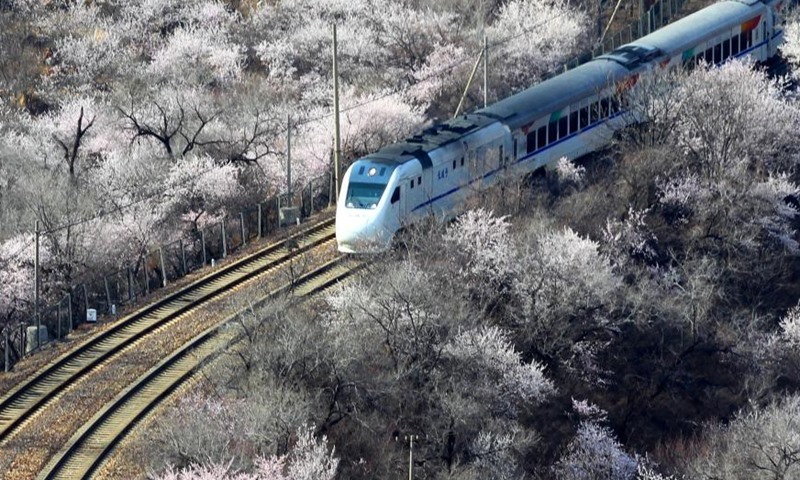 Chuyến tàu ngoại ô chạy gần đoạn Cư Dung quan của Vạn Lý Trường Thành ở thủ đô Bắc Kinh, Trung Quốc, ngày 23.3.2021. Ảnh: Tân Hoa Xã