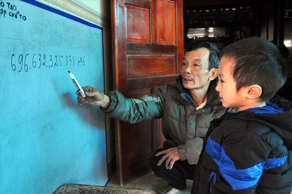 Ông Nguyễn Văn Trọng (bố đẻ) viết dãy số có 15 chữ số và cháu Triều đã đọc một cách chính xác. Ảnh: Minh Lý
