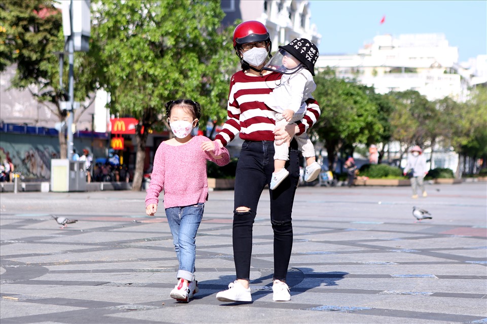 Nhiều gia đình diện áo ấm đi dạo tại Phố đi bộ Nguyễn Huệ (Quận 1).