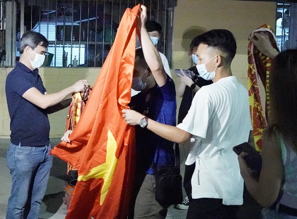 Người hâm mộ đội tuyển Việt Nam chuẩn bị quốc kỳ cổ vũ đội nhà. Ảnh: Glen Vu