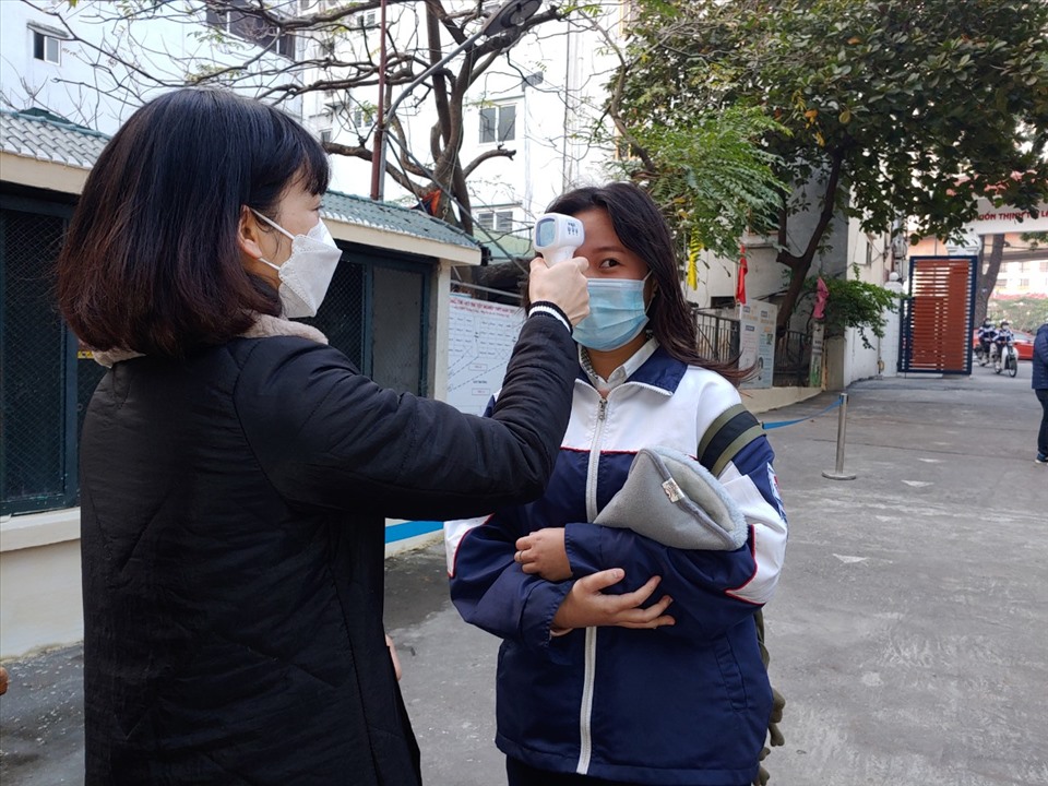 Học sinh Trường THPT Quang Trung (Đống Đa, Hà Nội) được đo thân nhiệt tại khu vực cổng trường. Ảnh: Tường Vân.