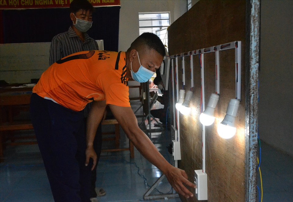Một học viên đã lắp đặt thành công hệ thống điện thắp sáng sau khi được thầy giáo tận tình hướng dẫn. Ảnh: LT