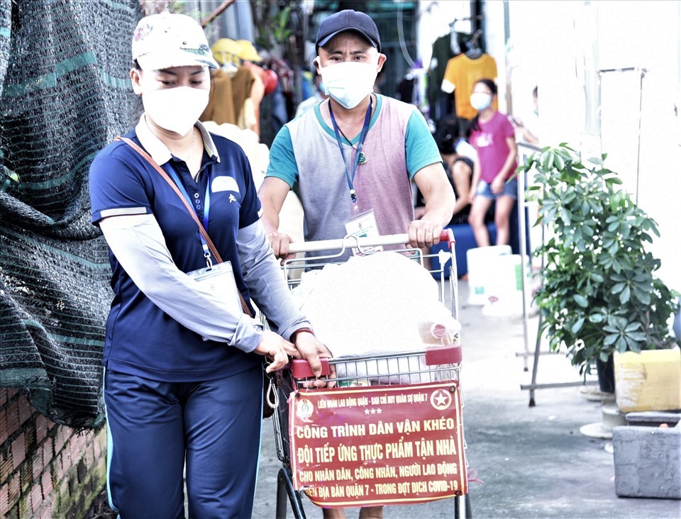 “Đội tiếp ứng thực phẩm tận nhà” gồm các tình nguyện của LĐLĐ quận phối hợp với Ban Chỉ huy quân sự quận 7 đến các phòng trọ tặng quà CNLĐ, người dân bị ảnh hưởng của dịch COVID-19. Ảnh: Nam Dương