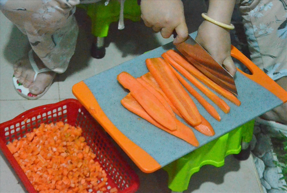 Cà rốt được cắt hạt lựu trước khi cho vào nồi cháo. Ảnh: LT