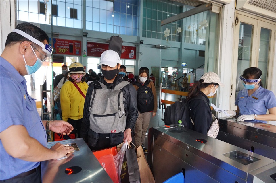 Hệ thống cổng soát vé tự động tại ga hoạt động trơn tru. Nhân viên đường sắt đeo khẩu trang, mặt nạ phòng dịch khi soát vé của hành khách.