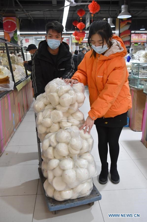 Hai người dân ở Thiểm Tây mua bánh để chuẩn bị cho Tết Nguyên đán. Ảnh: Tân Hoa Xã.