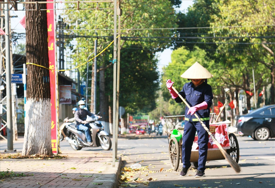 Trái ngược với cảnh nhộn nhịp, tươi vui ở trên, đâu đó vẫn còn những công nhân lao động tạm gạt đi hạnh phúc cá nhân để miệt mài với nhiệm vụ của mình nhằm giữ cho thành phố khang trang, xanh, sạch, đẹp trong những ngày xuân. Ảnh: Bảo Trung