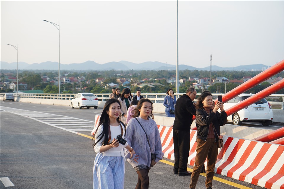 Dịp Tết, nhiều sinh viên các trường đại học-cao đẳng về quê, tranh thủ đi ngắm cảnh trên cây cầu mới nơi cửa biển quê hương. Ảnh: QĐ