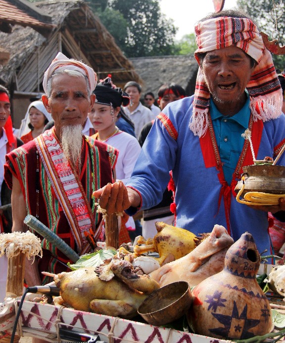 Già Lê Văn Ru (bên trái) tham gia một nghi lễ của đồng bào Chăm Hroi. Ảnh: Nguyễn Tri