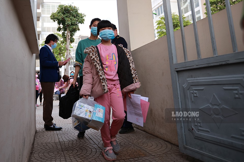 Em Nguyễn Ngọc Quỳnh Chi cùng mẹ là Nguyễn Thị Lợi hoàn thành việc cách ly 14 ngày tại Trường tiểu học Xuân Phương mang đồ đạc lên xe về nhà.