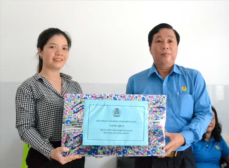 Ông Trần Thanh Việt trao quà tặng của LĐLĐ tỉnh cho đoàn viên Hồng Lụa. Ảnh: Lục Tùng