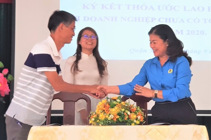 Bà Lê Thị Bích Hạnh - Chủ tịch LĐLĐ quận 5, TPHCM (bên phải) - cùng Giám đốc Cty TNHH Tư vấn và đầu tư DTL ký, trao thỏa ước lao động tập thể. Ảnh: Đức Long