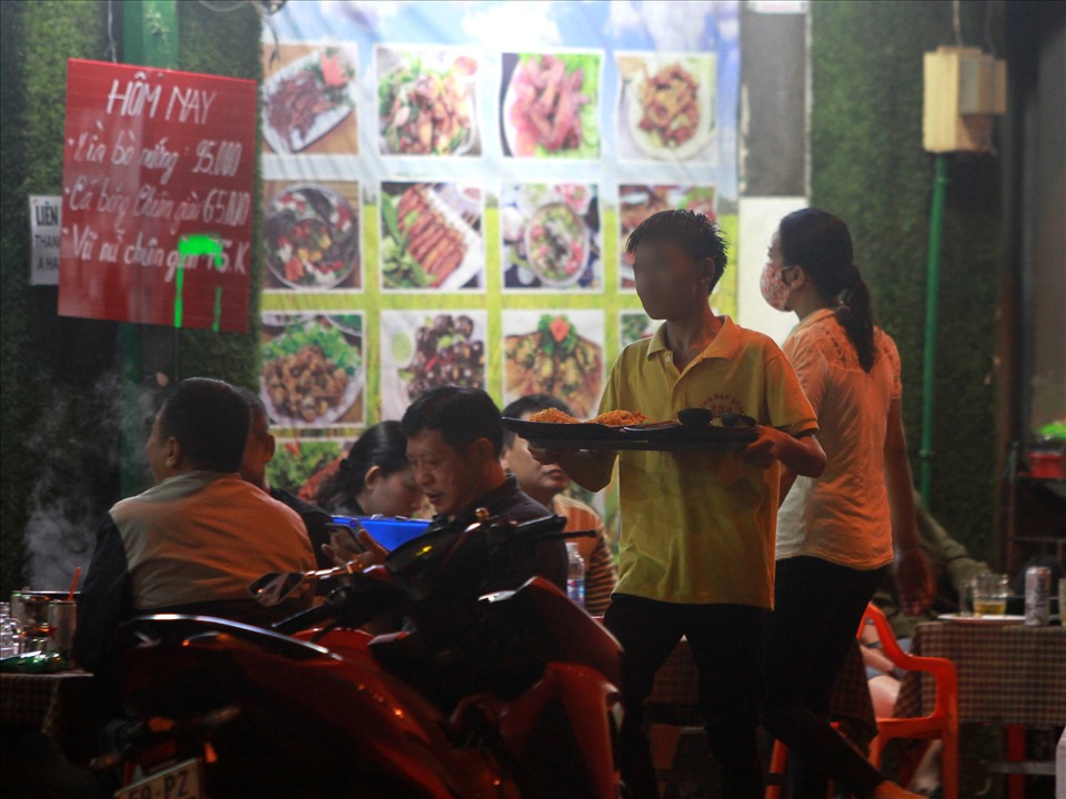 Nhân viên tại một quán nhậu trên đường Trần Hưng Đạo (quận 5) không mang khẩu trang khi phục vụ khách.