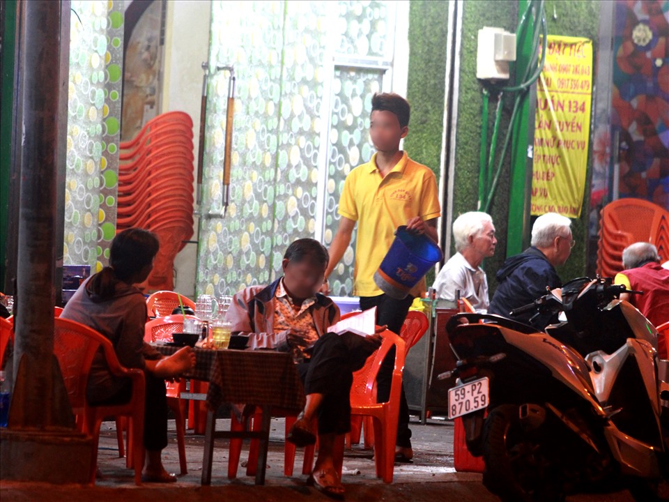 Nhân viên tại một quán nhậu trên đường Trần Hưng Đạo (quận 5) không mang khẩu trang khi phục vụ khách.