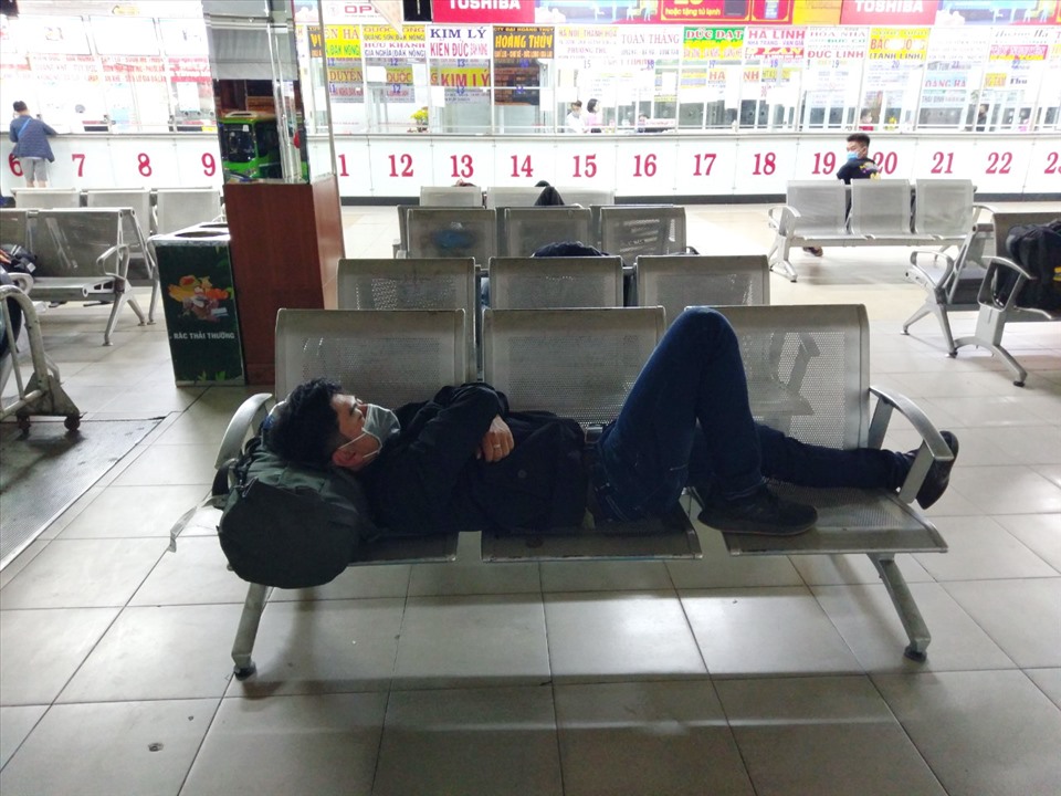 Anh Nguyễn Văn Bình ngủ tại bến xe chờ tới sáng đón xe buýt về nhà.  Ảnh: Minh Quân