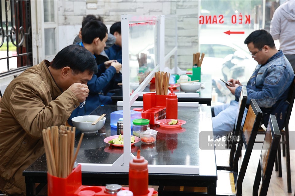 Để hạn chế tiếp xúc gần khi ăn uống, nhiều quán ăn tại Hà Nội đã chủ động dựng vách ngăn,  thực hiện các biện pháp bảo đảm an toàn phòng dịch.