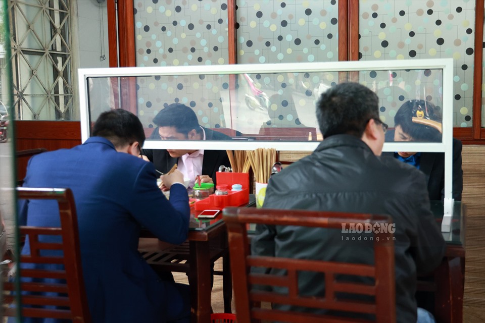 Tại quán phở Bà Tố trên đường Trung Kính (Hà Nội), số lượng bàn đã giảm khoảng 1/3 so với trước đợt dịch. Tại mỗi bàn đều có vách bằng mica cao hơn đầu thực khách khi ngồi.