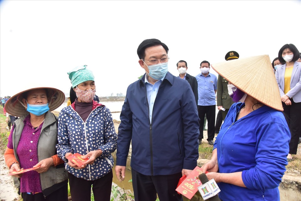 Bí thư Thành ủy Hà Nội Vương Đình Huệ và các lãnh đạo thành phố tặng quà cho nông dân xã Dị Nậu, huyện Thạch Thất.