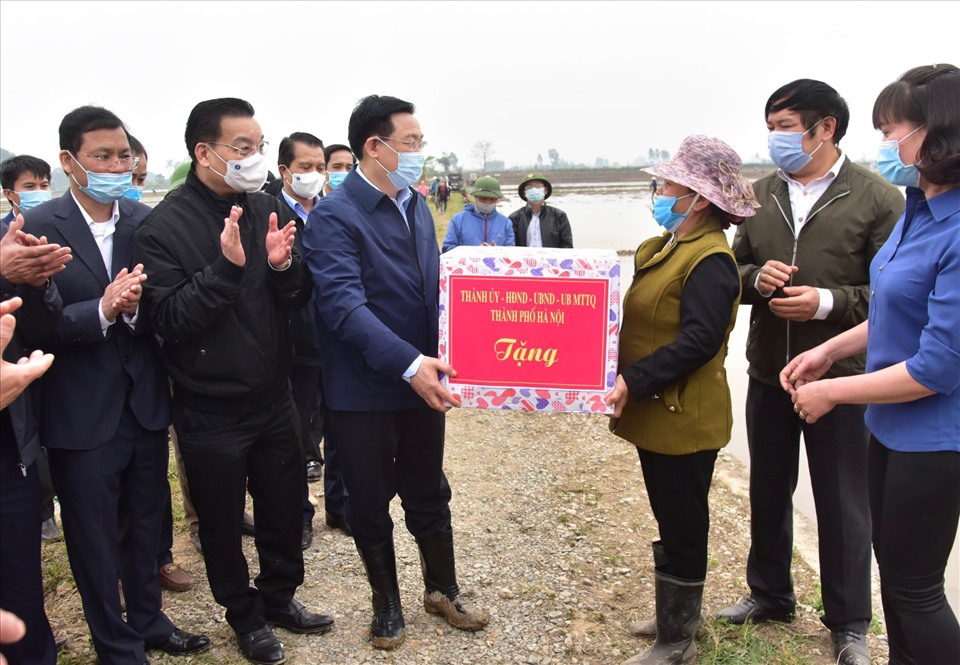 Bí thư Thành ủy Hà Nội Vương Đình Huệ và các lãnh đạo thành phố tặng quà cho nông dân xã Dị Nậu, huyện Thạch Thất.