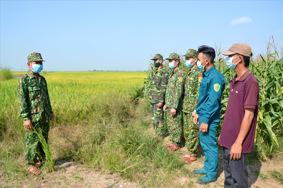 Cán bộ chiến sĩ Chốt phòng chống dịch COVID-19 số 8 thuộc Đồn Biên phòng cửa khẩu quốc tế Vĩnh Xương, Bộ đội biên phòng An Giang truyền đạt nội dung tăng cường kiểm soát, chốt chặt dường mòn lối mở của UBND tỉnh An Giang. Ảnh: Lục Tùng