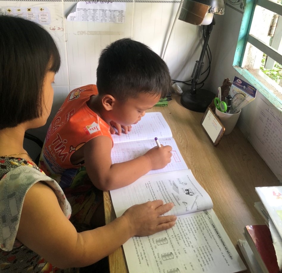 Chị Triệu Thị Huyền đang tranh thủ dạy con khi phải nghỉ học ở nhà để phòng dịch COVID-19. Ảnh Đức Long