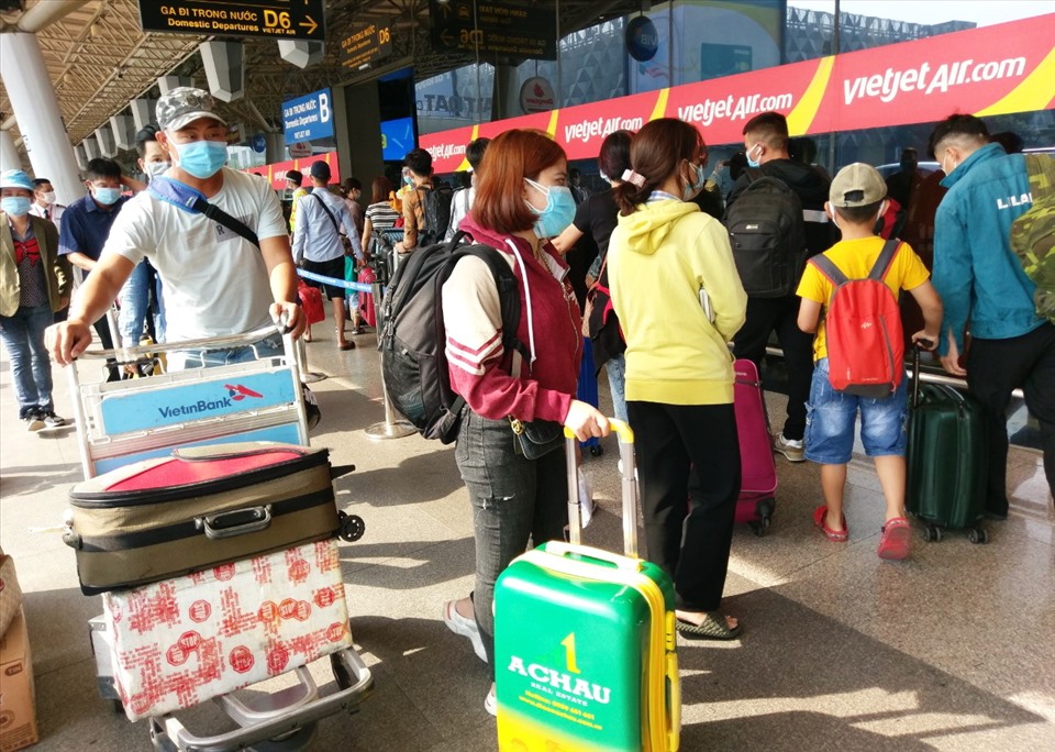 Hôm nay sân bay Tân Sơn Nhất đông đúc hơn rất nhiều những ngày trước đó. Người nào cũng kín mít khẩu trang, tay xách nách mang nhiều hành lý mong được về quê sớm với gia đình vào dịp Tết.