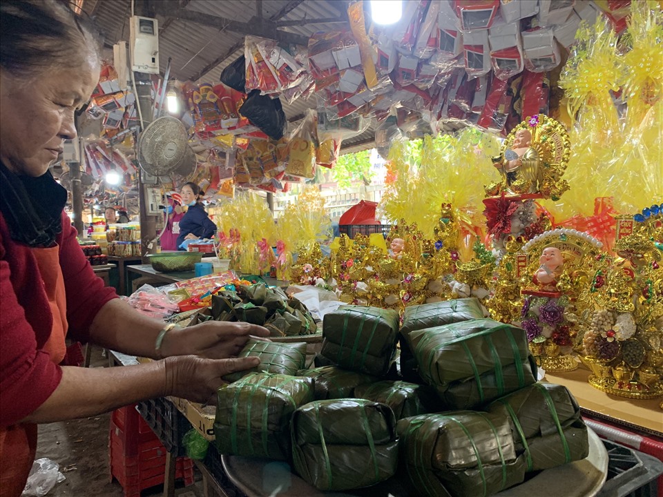 Bà Nguyễn Thị Cầu thu dọn những cặp bánh chưng không bán được để tan chợ. Ảnh: ĐD