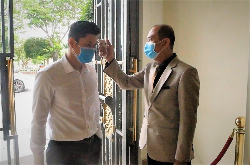 Nhân viên Khách sạn Majestic Saigon kiểm tra thân nhiệt khách. Ảnh: Anh Tú