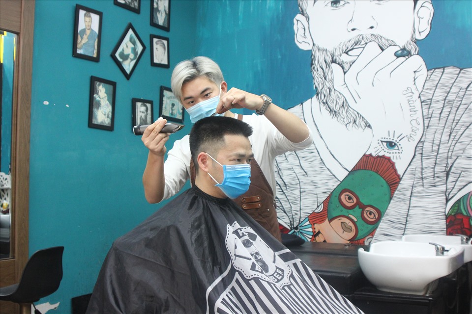 Nhân viên cắt tóc cẩn thận từng động tác, chăm sóc cho khách hàng. Ảnh T.Vương