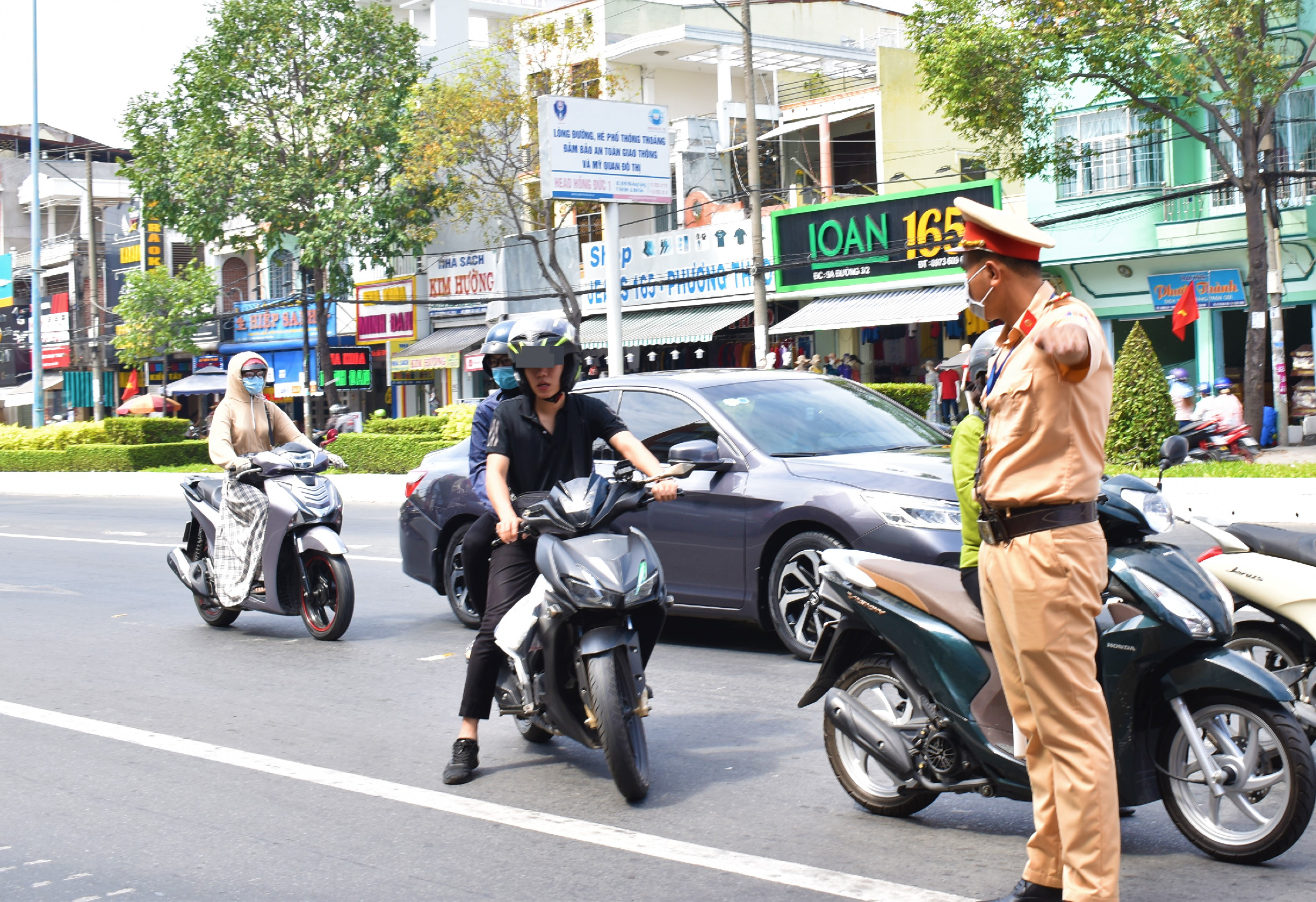 Lực lượng công an quận Ninh Kiều kiểm tra, tuyên truyền, nhắc nhở người dân thực hiện các biện pháp phòng, chống dịch COVID-19. Trong ảnh là công an quận Ninh Kiều nhắc nhở và phát khẩu trang cho người dân. Ảnh: Thành Nhân