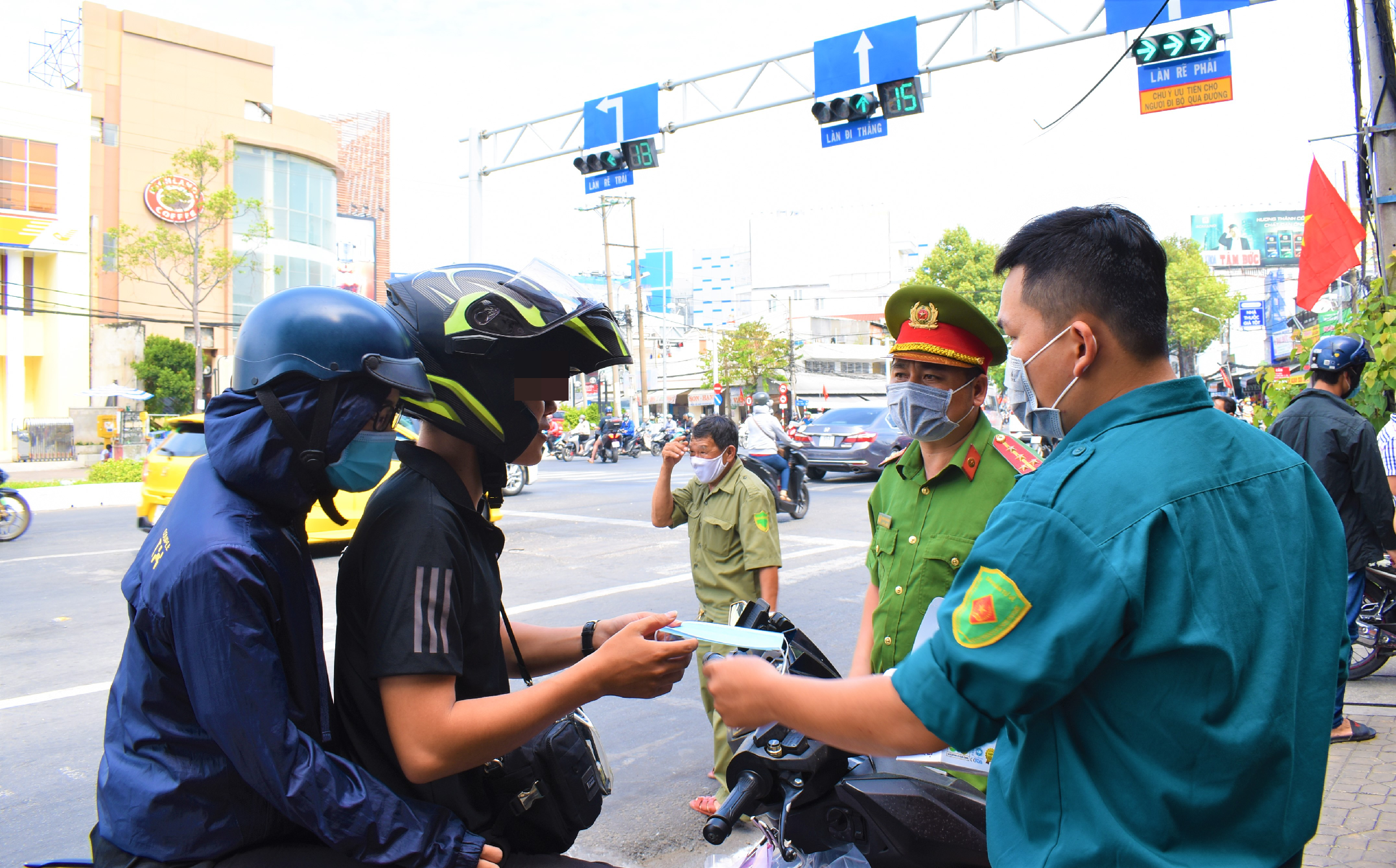 Lực lượng công an quận Ninh Kiều kiểm tra, tuyên truyền, nhắc nhở người dân thực hiện các biện pháp phòng, chống dịch COVID-19. Trong ảnh là công an quận Ninh Kiều nhắc nhở và phát khẩu trang cho người dân. Ảnh: Thành Nhân