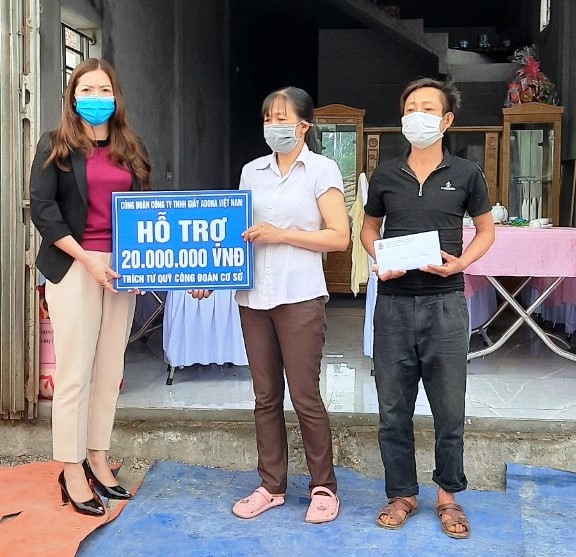 Đại diện công đoàn Công ty trao tiền hỗ trợ cho gia đình chị Phạm Thị Lan. Ảnh: NT