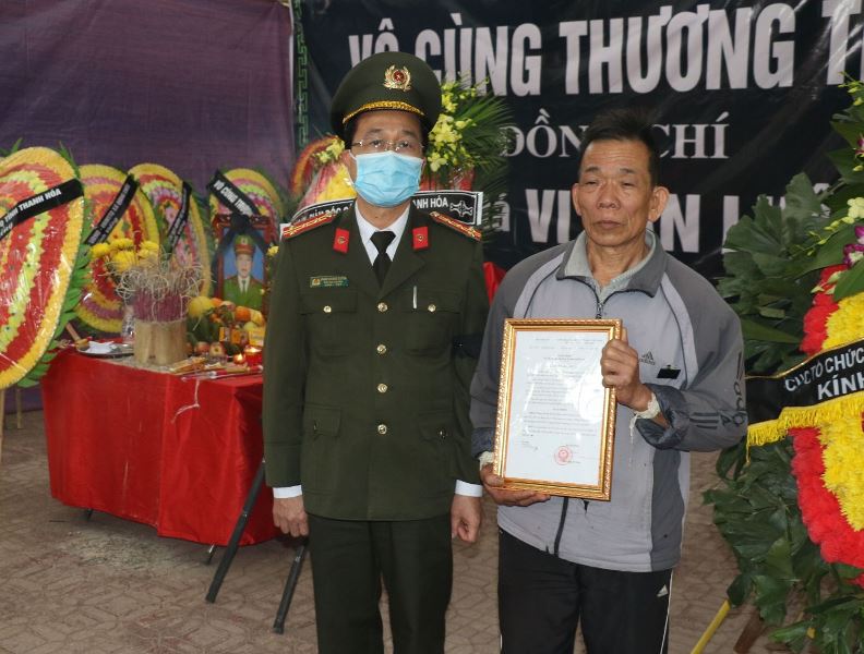 Trao quyết định thăng cấp bậc hàm trước hạn cho gia đình Trung tá Vi Văn Luân, người đã anh dũng hy sinh khi vây bắt tội phạm. Ảnh: CATH