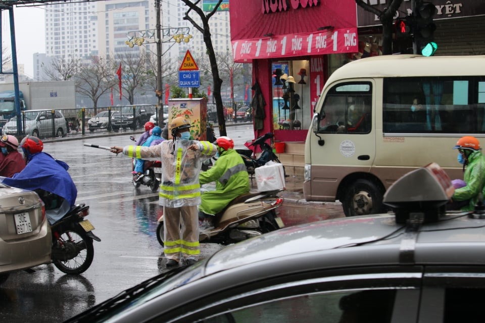 Lực lượng Cảnh sát giao thông căng mình phân luồng giao thông dưới mưa ngày 30 Tết Nguyên đán Tân Sửu 2021, tại nút Bến xe Nước Ngầm (quận Hoàng Mai, Hà Nội). Ảnh: V.Dũng.