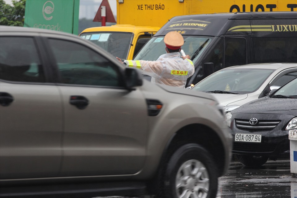 CSGT đội mưa phân luồng giao thông, đảm bảo an ninh trật tự.
