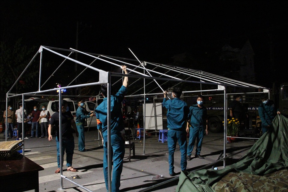 Từ 23h đêm 9.2, lực lượng chức năng bắt đầu gỡ lều bạt ở đầu khu phong tỏa. Ảnh: Đình Trọng