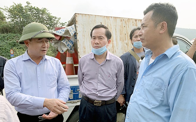 Tổng Cục trưởng Tổng cục Đường bộ Việt Nam Nguyễn Văn Huyện (đứng giữa) và lãnh đạo huyện Văn Yên (ngoài cùng bên trái) tuyên truyền, vận động người dân không kinh doanh tại khu vực hai bên đường cao tốc Nội Bài - Lào Cai. (Ảnh: Thu Trang)