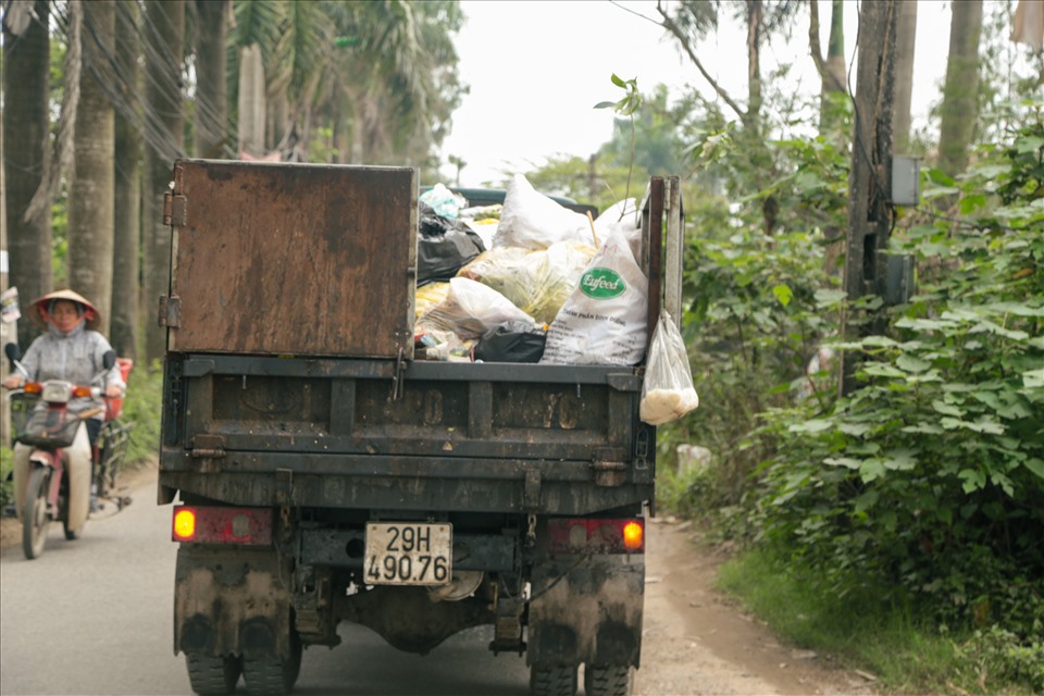 Các xe rác chất đầy rác thải nhưng không được che chắn cẩn thận. Ảnh: Hương Ánh