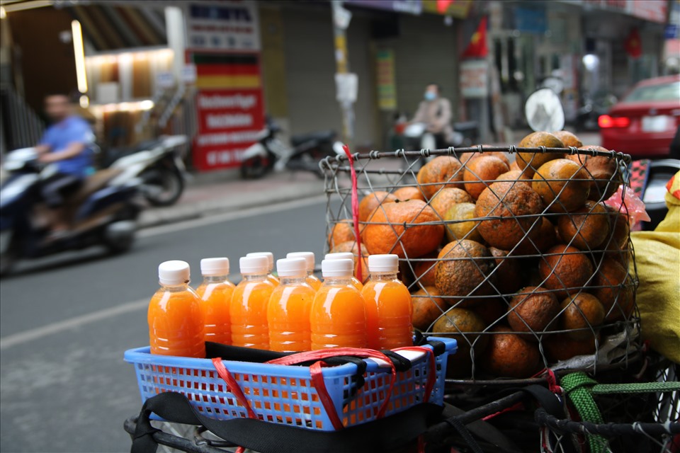 Những chai nước cam được bày bán trên những sọt cam nặng trĩu. Trung bình một chai 330 ml  với giá 10.000 đồng.