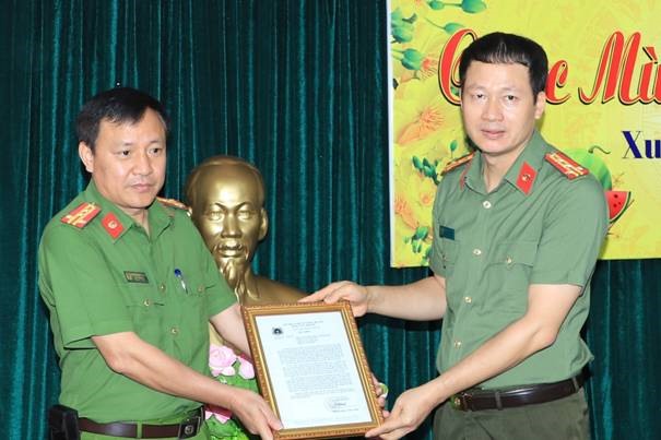 Đại tá Vũ Hồng Văn (phải) nhận thư khen của lãnh đạo Bộ Công an sau chuyên án phá đường dây 200 triệu lít xăng giả. Ảnh CAĐN