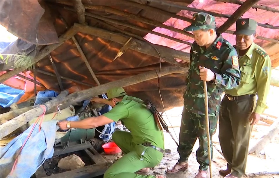 Lực lượng quân đội cùng công an kiểm tra bên trong một lán trại trước khi đánh sập hầm vàng.
