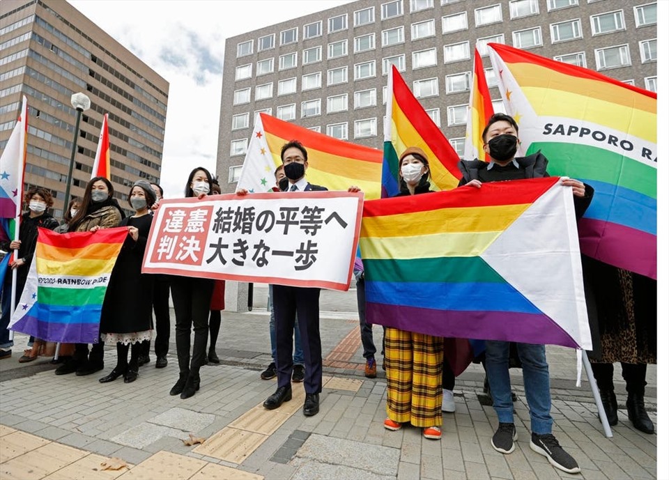 Các luật sư và những người ủng hộ của nguyên đơn cầm cờ cầu vồng và biểu ngữ có nội dung: “Phán quyết bất hợp pháp” bên ngoài Tòa án quận Sapporo, miền bắc Nhật Bản. Ảnh: AFP
