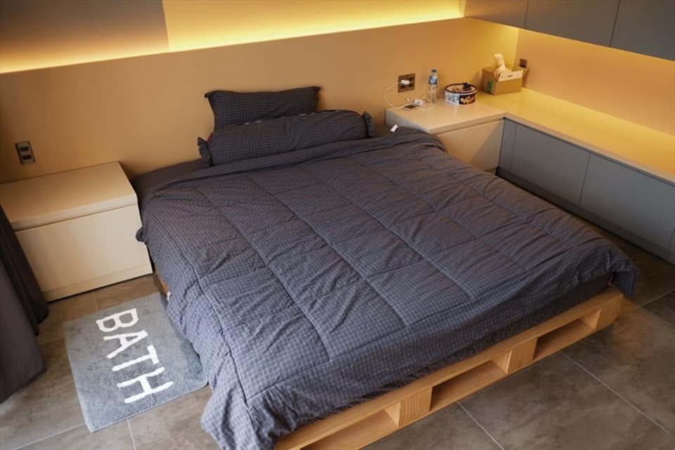 Phòng ngủ tông màu vàng sáng, sử dụng drap giường màu tối.