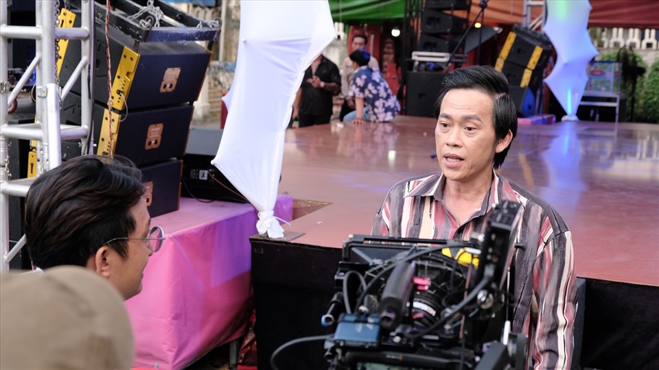 Trong ảnh, NSƯT Hoài Linh đang thảo luận cùng đạo diễn, xung quanh là các máy móc thiết bị quay hình. Ảnh: NSCC