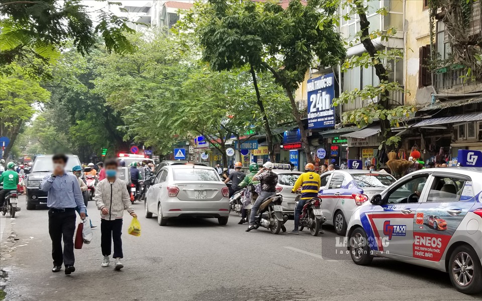 Xe taxi các hãng “dàn trận” trước cổng Bệnh viện Việt Đức, trong khi đó lưu lượng giao thông qua khu vực này rất lớn. Ảnh: Huy Hoàng