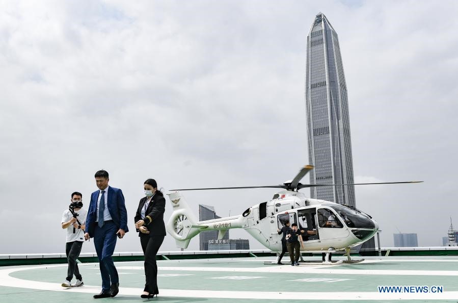 Hành khách (giữa) trên chuyến bay bằng trực thăng đầu tiên đến sân bay. Ảnh: Xinhua