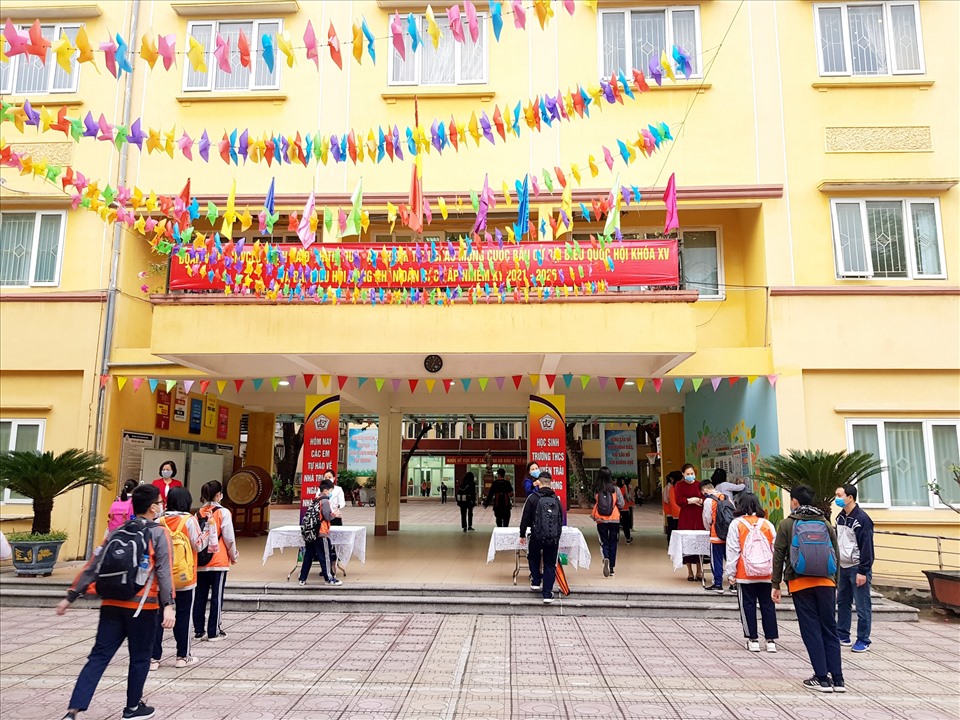 Tại trường THCS Nguyễn Trãi, học sinh trước khi vào trường được xếp hàng để đo thân nhiệt. Học sinh đeo khẩu trang đầy đủ khi ra vào trường.